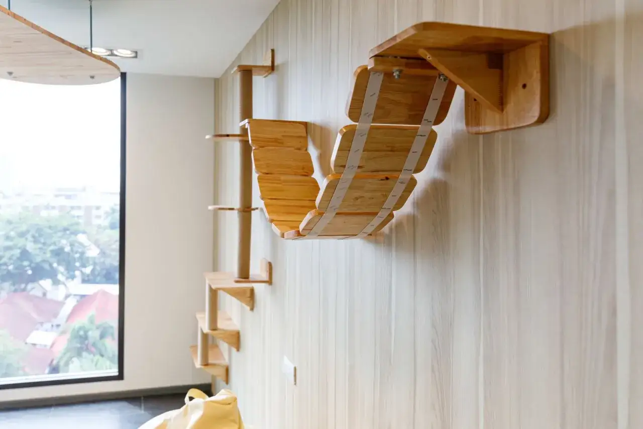 Eine moderne Katzenkletterwand aus Holz, die zum selber bauen inspiriert. Mehrere Ebenen und eine Hängebrücke laden zum Spielen ein.